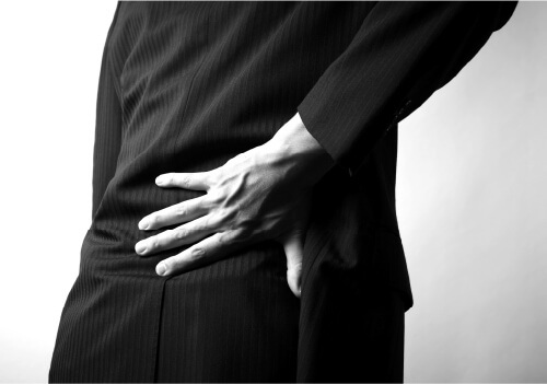 腰を押さえて痛がる人